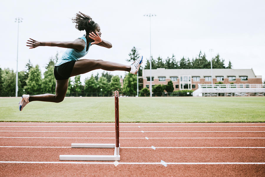 Woman Athlete Runs Hurdles for Track and Field Photograph by RyanJLane