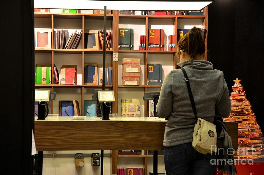 Woman browses kindle and books at bookshop Photograph by Imran Ahmed