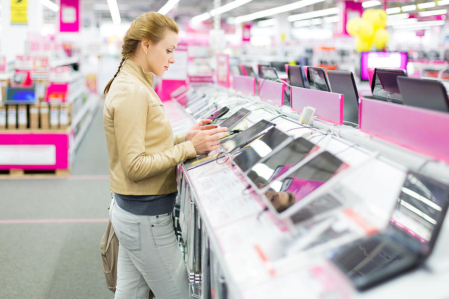 Woman buys a digital tablet at store Photograph by 97