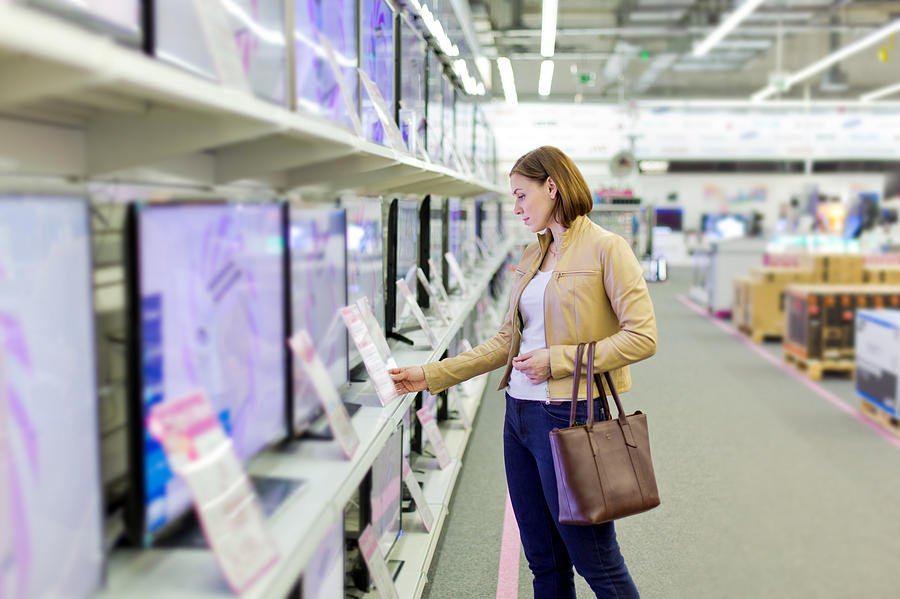 woman chooses a TV in the store Photograph by 97