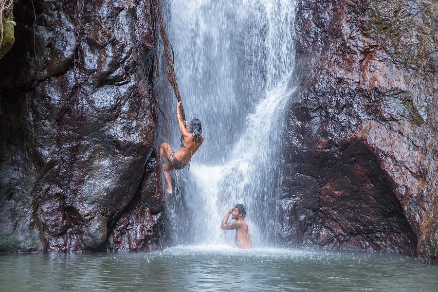 Woman climbing on the side of a waterfall in an island, Fiji Photograph by Matteo Colombo