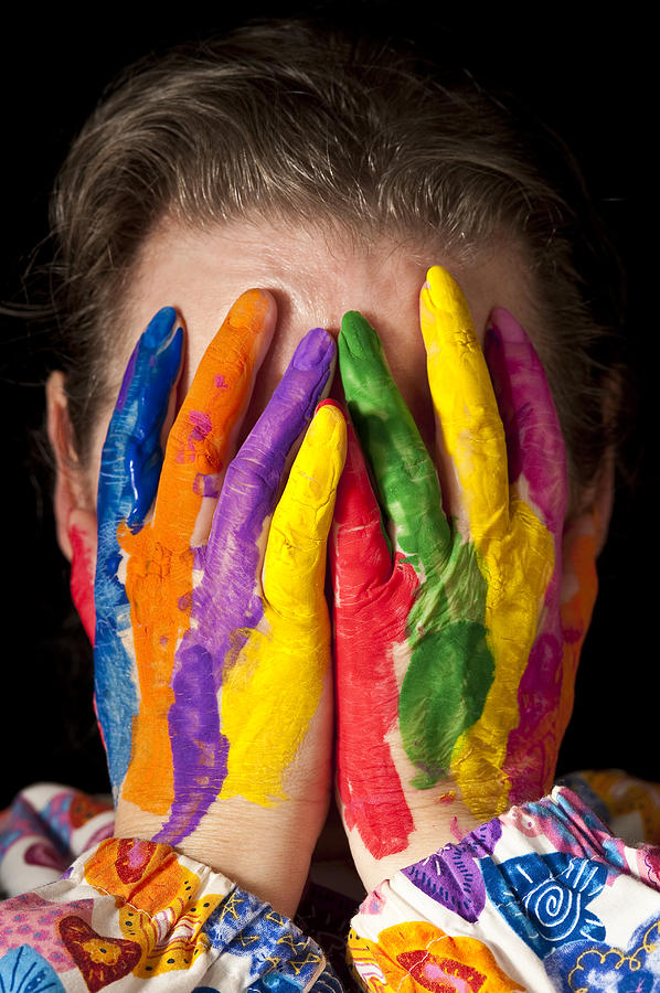 Woman concealing face behind multicolored fingers Photograph by Jim Corwin