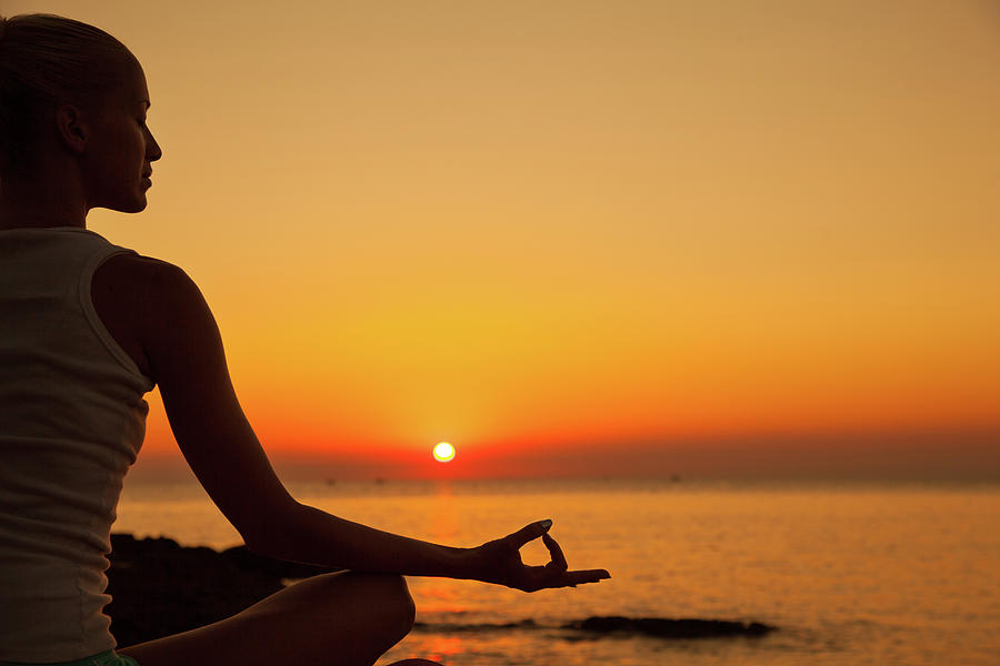 Woman Doing Meditation At Sunset by Emirmemedovski