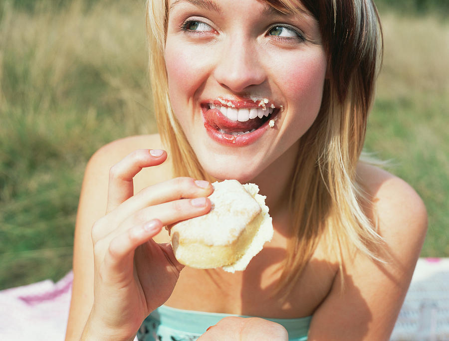 Woman eating a cake Photograph by Image Source