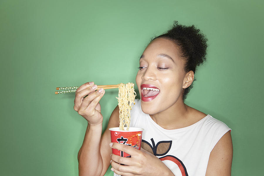 Woman Eating Takeaway Noodles With Chopsticks Photograph by Tara Moore