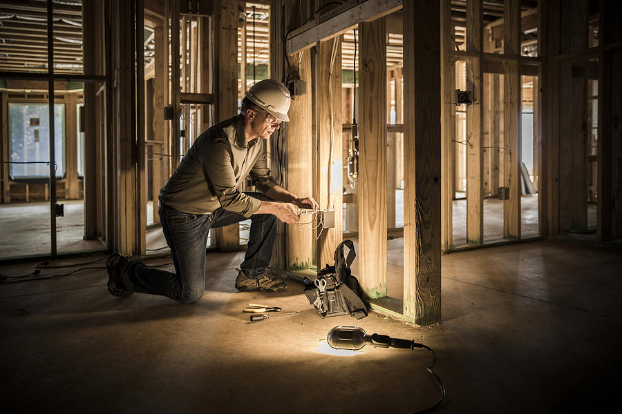 Woman electrician at home construction site. Photograph by Stevecoleimages
