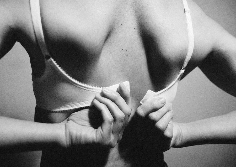 Woman fastening bra, rear view, close-up, b&w Photograph by Laurent Hamels