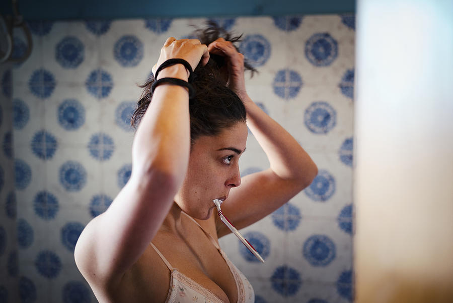 Woman Fixing Her Hair And Brushing Teeth At The Same Time Photograph by Justin Case