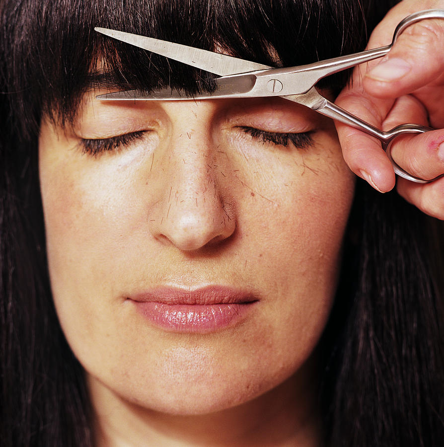 Woman getting bangs cut, eyes closed, close-up Photograph by James Darell