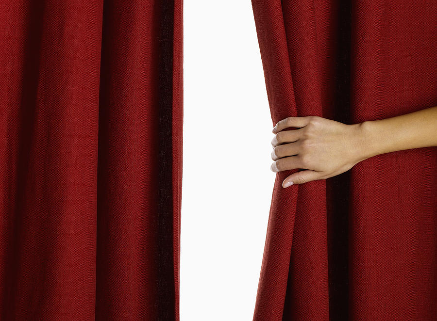 Woman hand pulling curtain, close-up Photograph by Jeffrey Hamilton