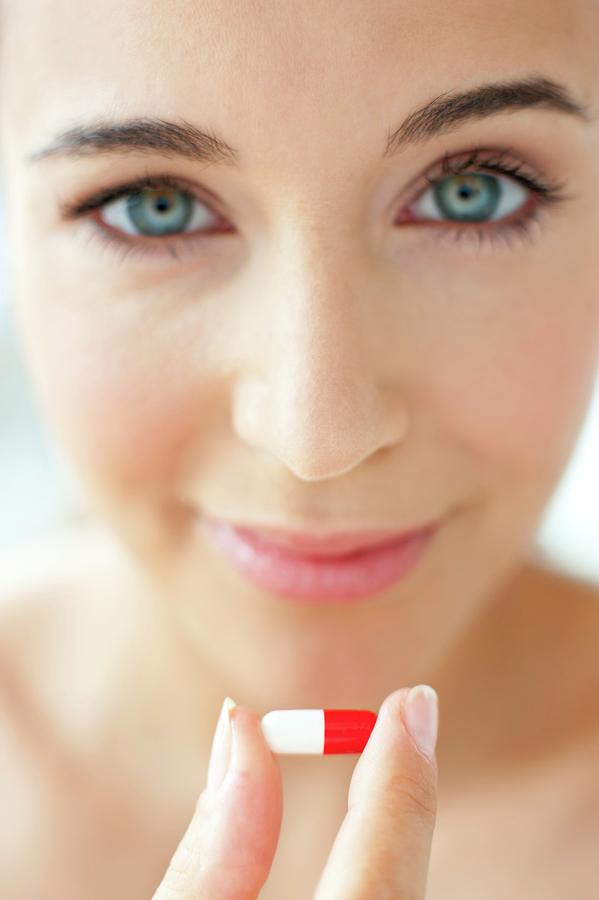 Woman Holding A Red And White Capsule Photograph by Ian Hooton