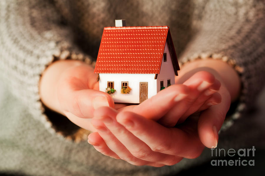 Woman holding a small new house in her hands Photograph by Michal Bednarek