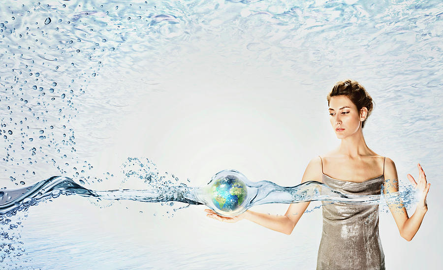 Woman Holding Globe Surrounded By Water Photograph by Ikon Ikon Images