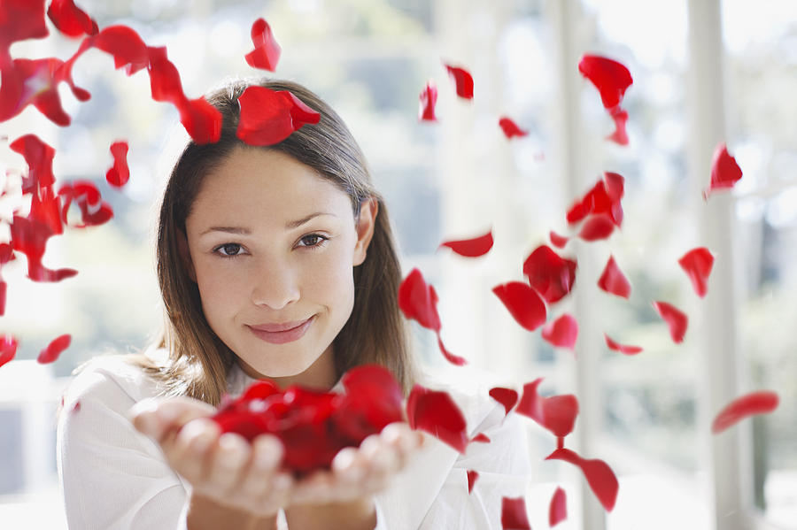 Woman holding handful of flower petals Photograph by Tom Merton