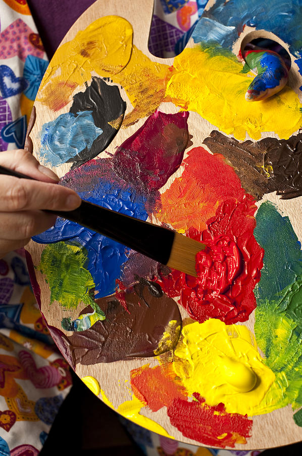 Woman holding multicolored palette and paintbrush  Photograph by Jim Corwin