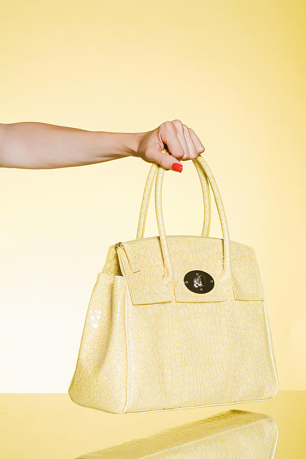 Woman holding yellow handbag Photograph by Image Source