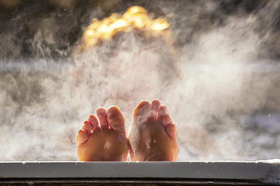 Woman holds her feet up while in a hot tub Photograph by Brazzo