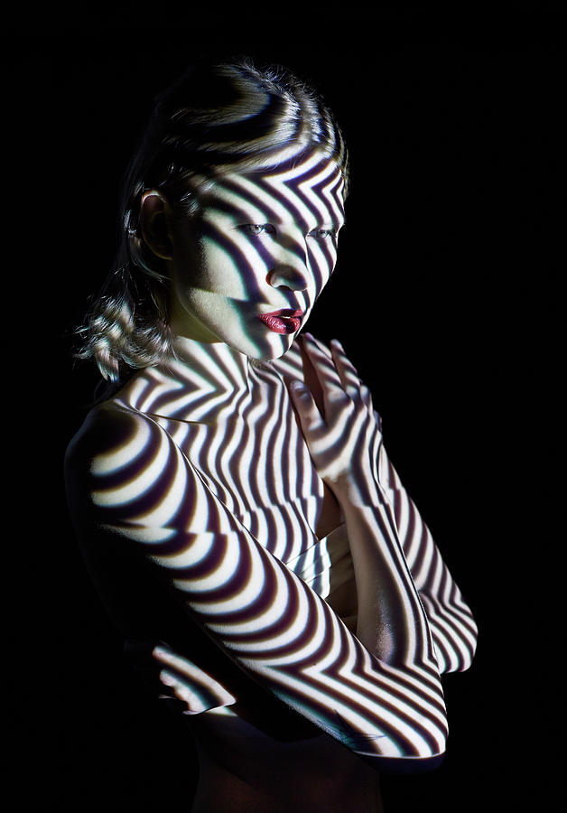 Woman In Abstract Lighting Looking To Photograph by Mads Perch