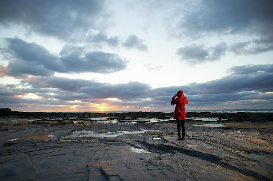 Woman In Red Coat On Coastline At Photograph by Dougal Waters