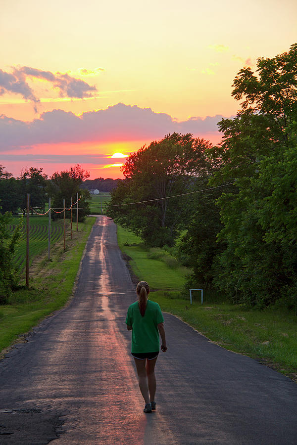 Woman Jogging On Country Road At Sunset Photograph by Matt Champlin