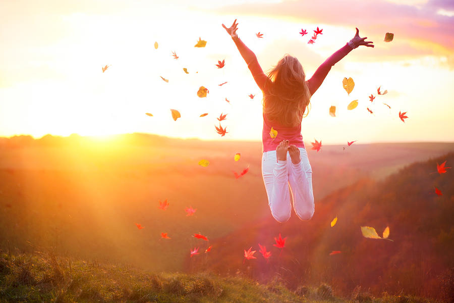 Woman Jumping at Sunset with Autumn Leaves Photograph by Sasha Bell