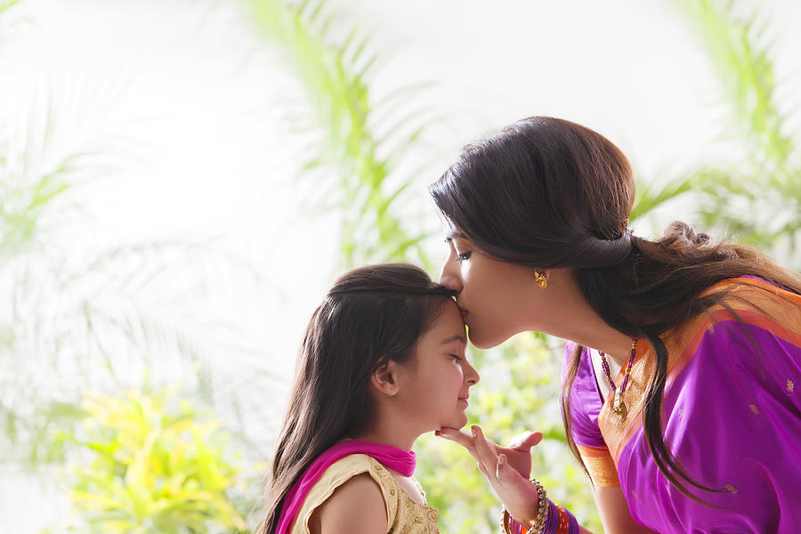 Woman kissing her daughters forehead Photograph by Hemant Mehta