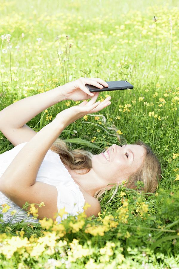 Woman Lying On Grass With Cell Phone Photograph By Ian Hootonscience Photo Library Fine Art