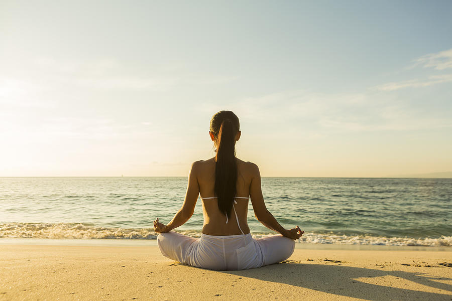 Woman meditating on beach Photograph by Felixhug