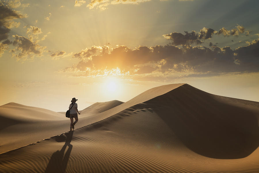 Woman on a sand dune at sunset Photograph by Buena Vista Images