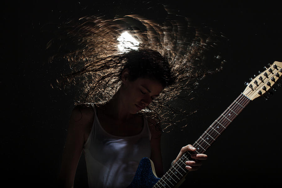 Woman Playing Guitar In Spotlight Photograph by Nisian Hughes