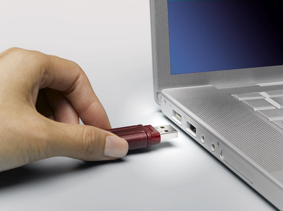 Woman Plugging In Memory Stick In Laptop Photograph by Jeffrey Coolidge