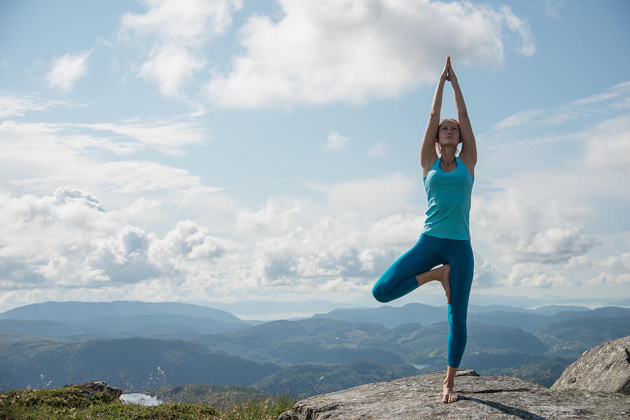 Woman practicing yoga on top of a mountain Photograph by Tatiana Kolesnikova