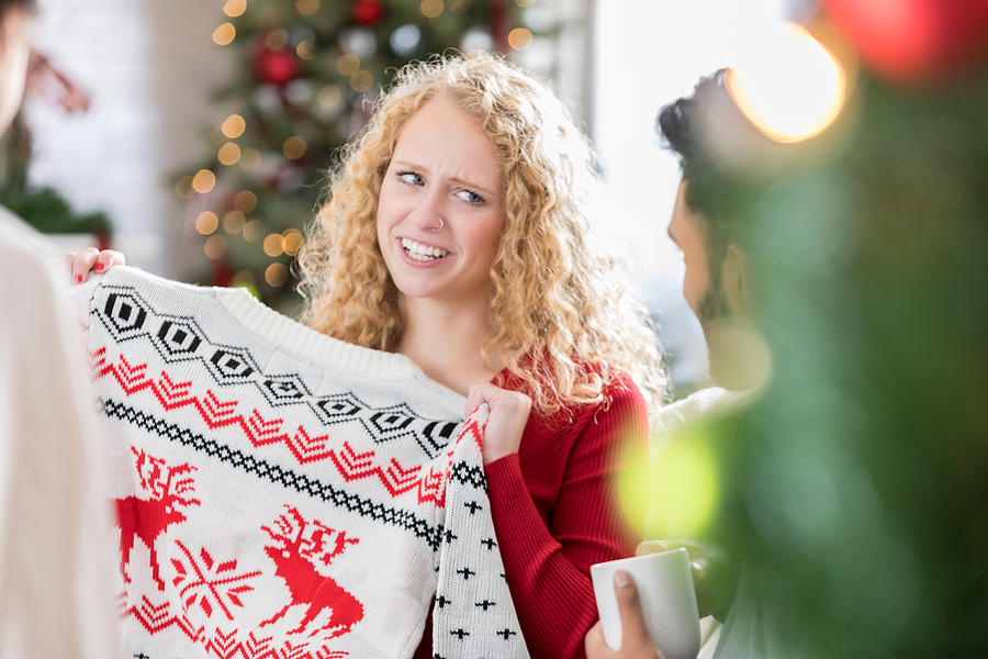 Woman receives ugly Christmas sweater at party Photograph by SDI Productions
