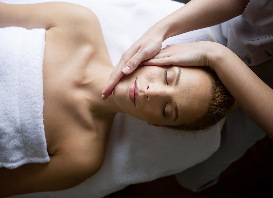 Woman receiving massage from female therapist in spa Photograph by Cavan Images