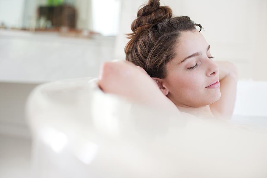 Woman relaxing in bubble bath Photograph by Sam Edwards