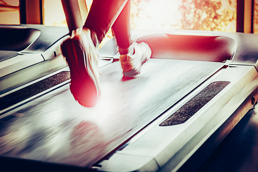 Woman running on treadmill Photograph by Mbbirdy