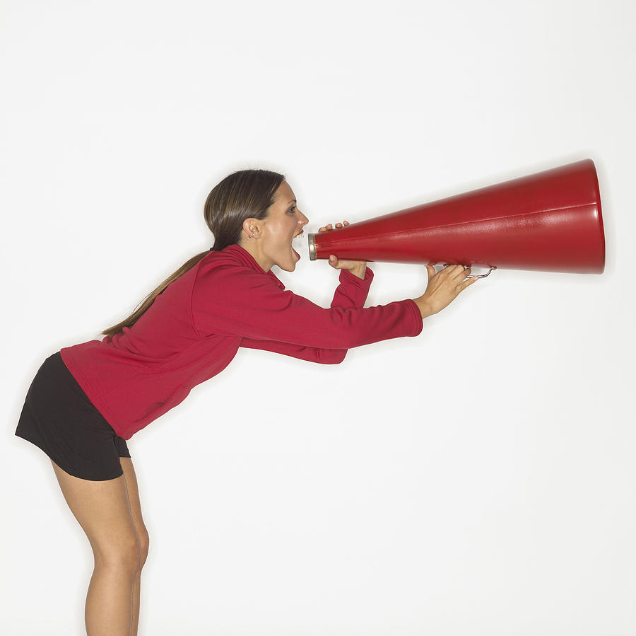 Woman screaming into bullhorn Photograph by Brand X Pictures