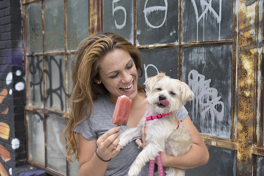 Woman sharing popsicle with morkie dog Photograph by Gary S Chapman