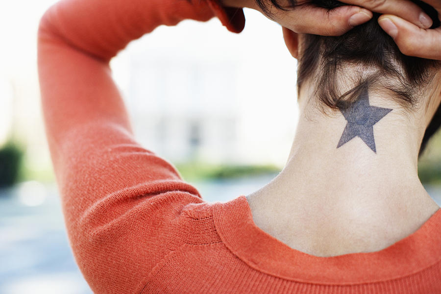 Woman Showing Her Star Tattoo Photograph by Fuse