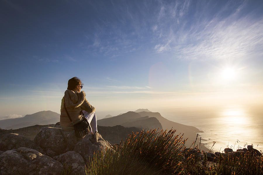 Woman sitting at sunset on Table Mountain Photograph by Chris Tobin