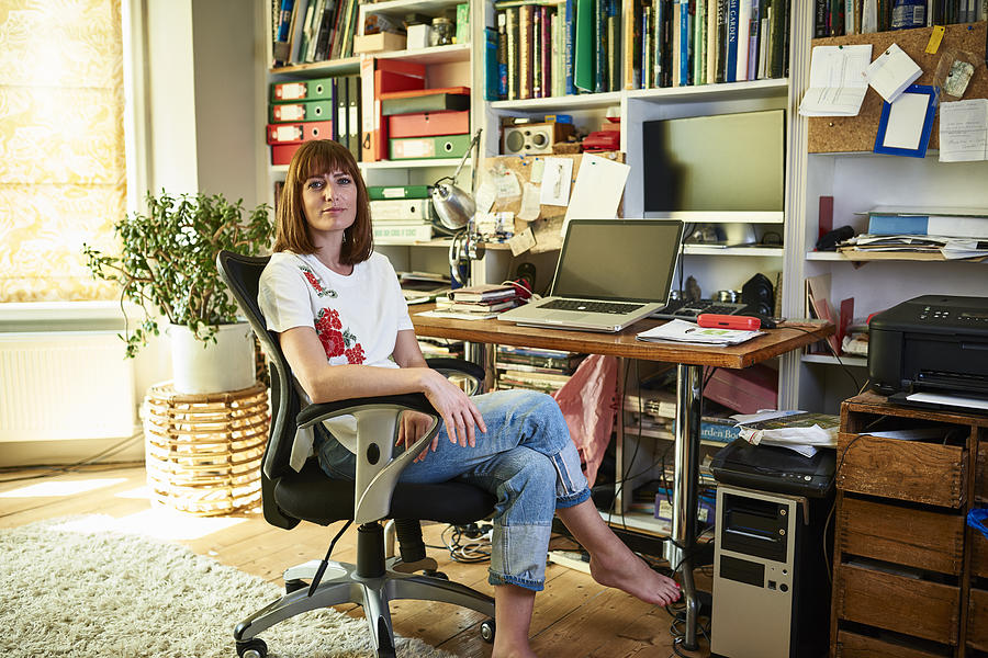 Woman sitting in home office Photograph by 10000 Hours