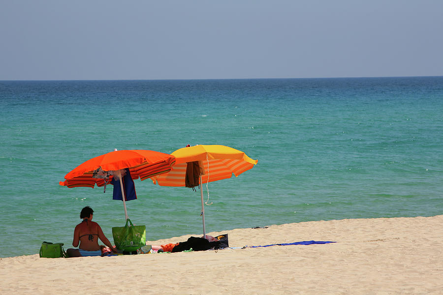 Woman Sitting Under Beach Umbrellas On by Max Paoli