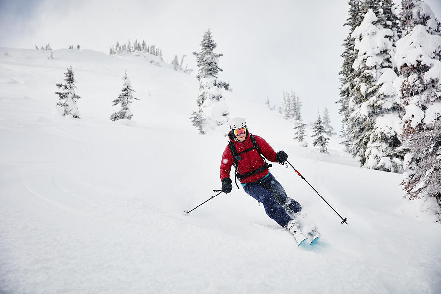 Woman skiing fresh snow while on backcountry ski tour Photograph by Thomas Barwick