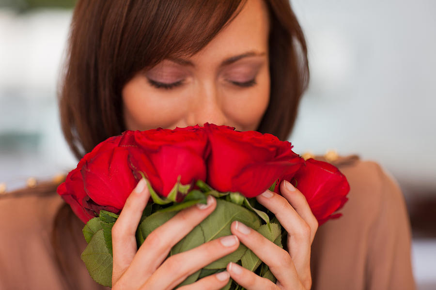 Woman smelling roses Photograph by Tom Merton