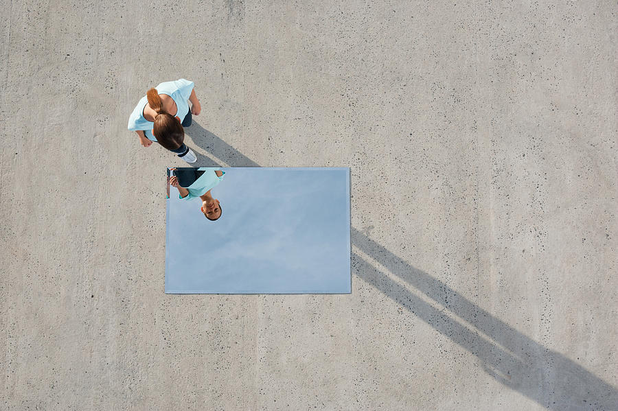 Woman standing above mirror and reflection outdoors Photograph by Martin Barraud