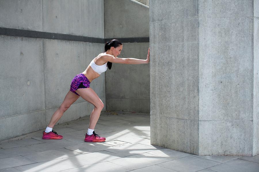 Woman Stretching Against Wall Photograph by Science Photo Library ...