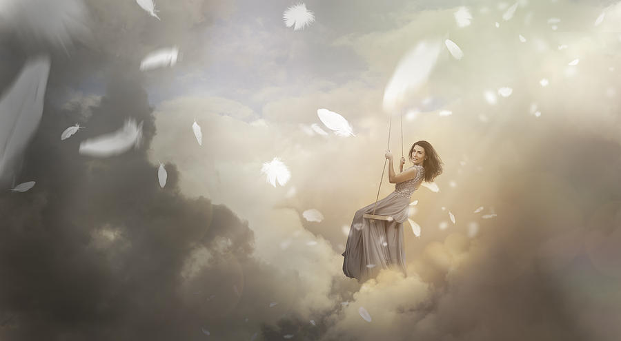 Woman swinging in sky with falling feathers Photograph by Pick-uppath