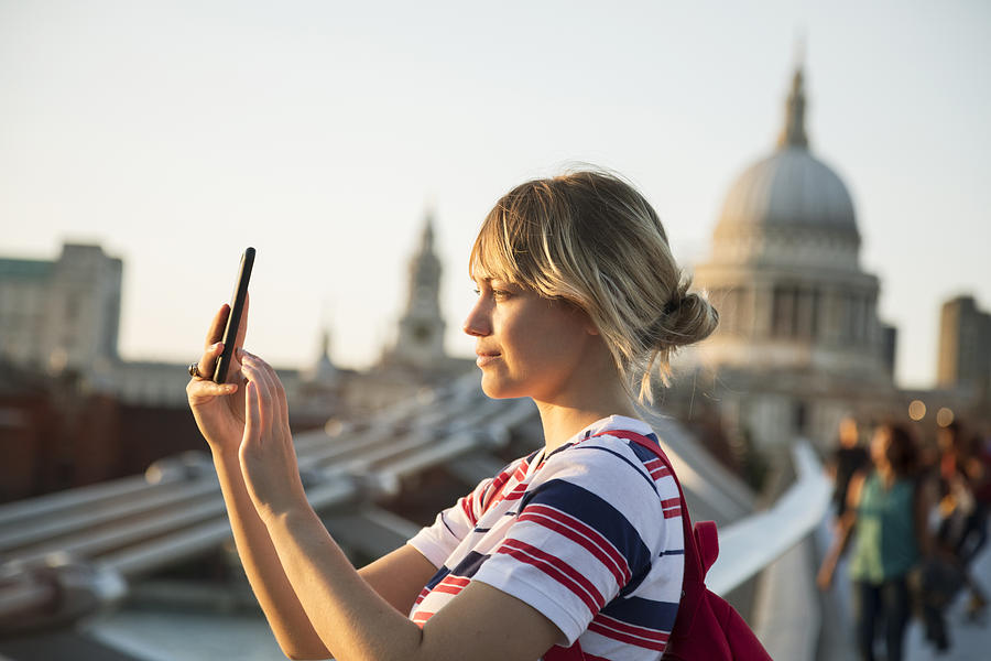 Woman takes photos with smartphone, st Pauls cathedrale in background. Photograph by Betsie Van Der Meer