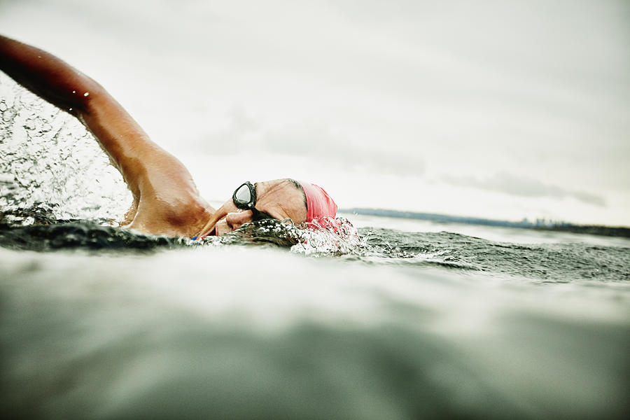 Woman taking a breath during open water swim Photograph by Thomas Barwick