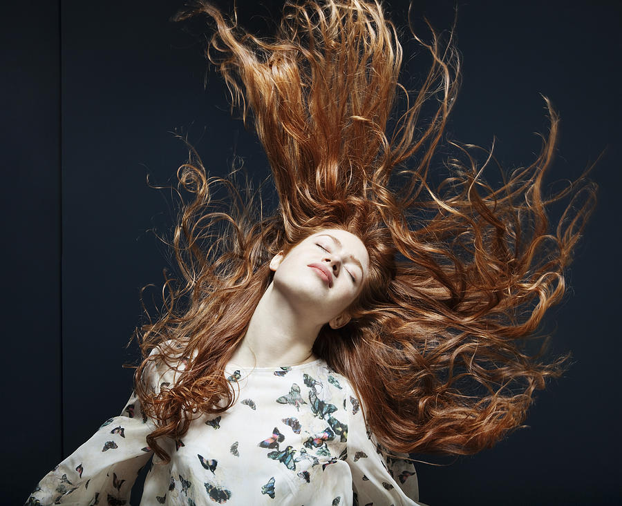 Woman tossing her hair in the wind. Photograph by Betsie Van der Meer
